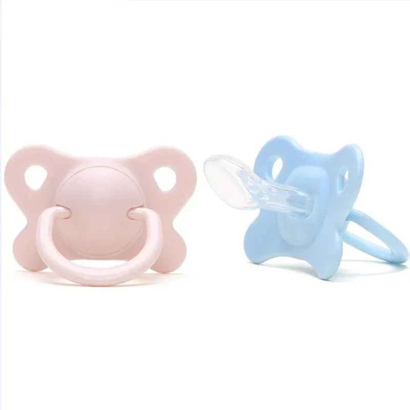 Pink and blue baby pacifiers made of silicone with ergonomic designs on white background