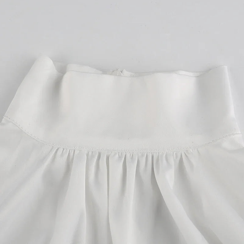 Close-up of white high-waisted skirt with stitched waistband and gathered fabric details