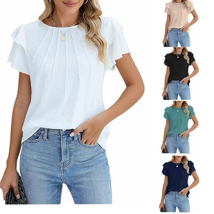 Woman wearing pleated flutter sleeve blouse in white, black, beige, teal, and navy with denim jeans