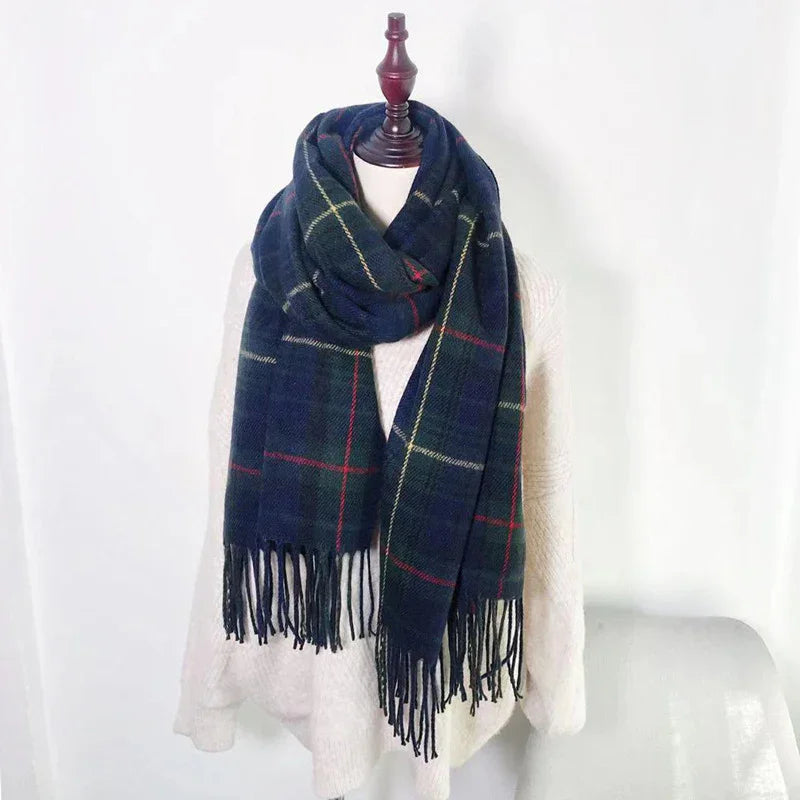 Navy blue plaid scarf with fringe on white mannequin wearing soft white sweater against plain white background