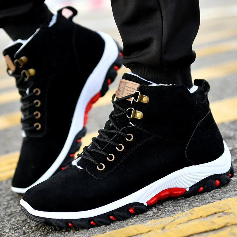 Black high-top winter sneakers with white and red rubber soles on pavement