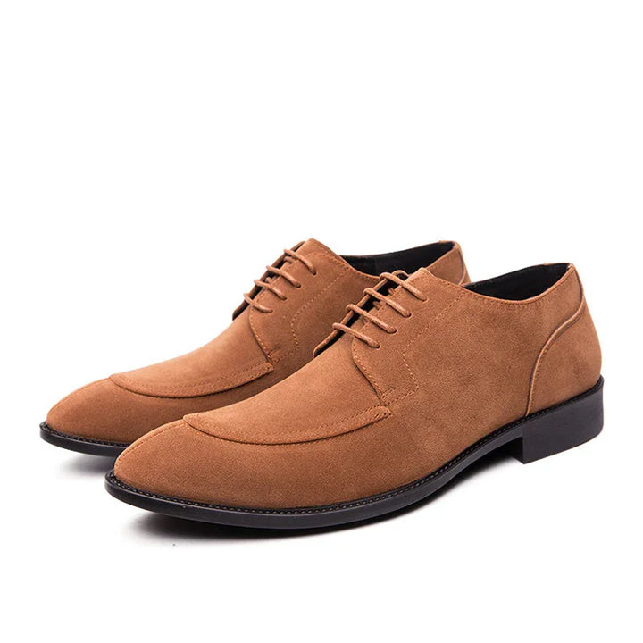 Pair of brown suede men's dress shoes with lace-up design and black soles on white background