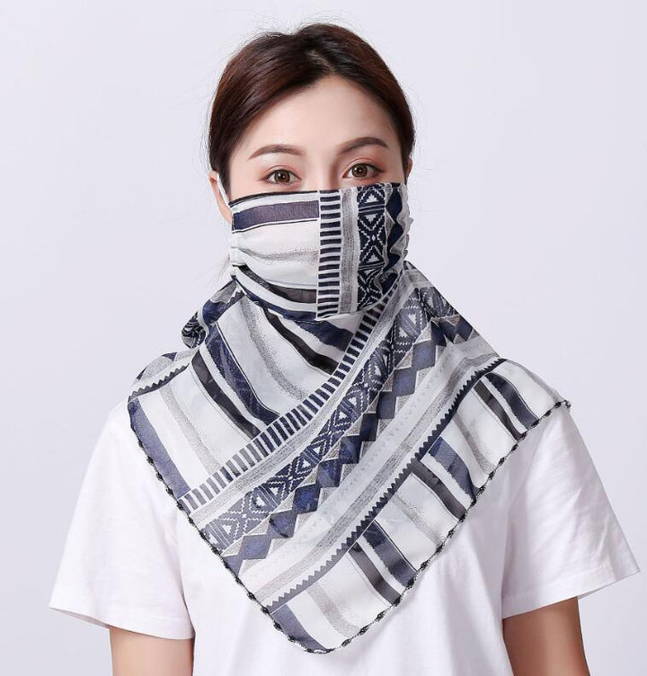 Woman wearing a patterned blue and white geometric print scarf as face mask and neck covering