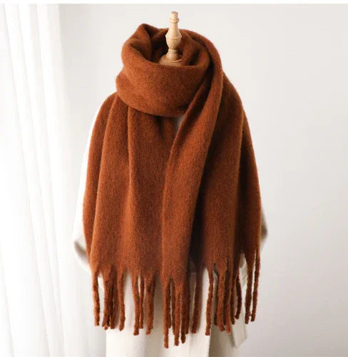 Rust brown oversized cozy scarf with fringed edges displayed on a mannequin against a white background