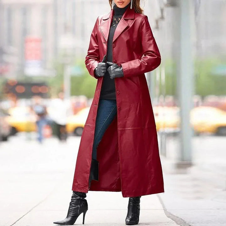 Woman in long red leather coat with black gloves, turtleneck, jeans, and high-heeled boots on city street