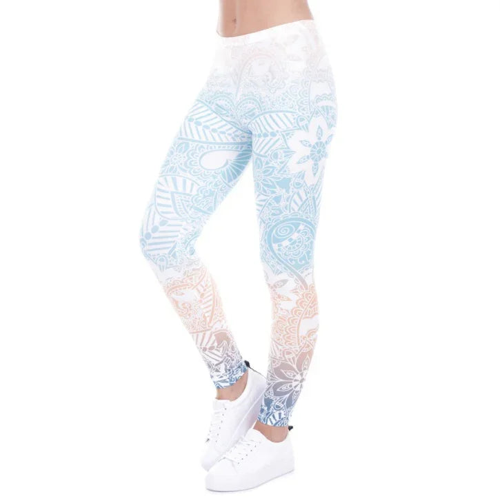 Woman wearing white leggings with blue and orange floral paisley pattern and white sneakers on white background