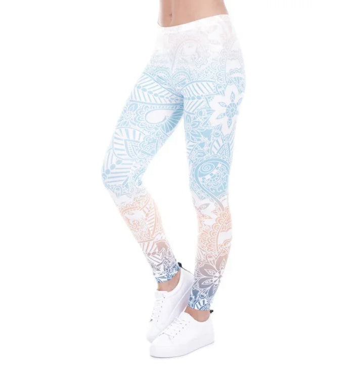 Woman wearing white leggings with blue and orange floral paisley pattern and white sneakers on white background