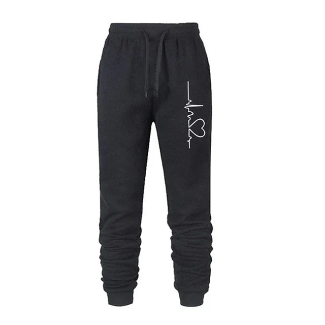 Black jogger pants with elastic waistband and white heart pulse design on left thigh