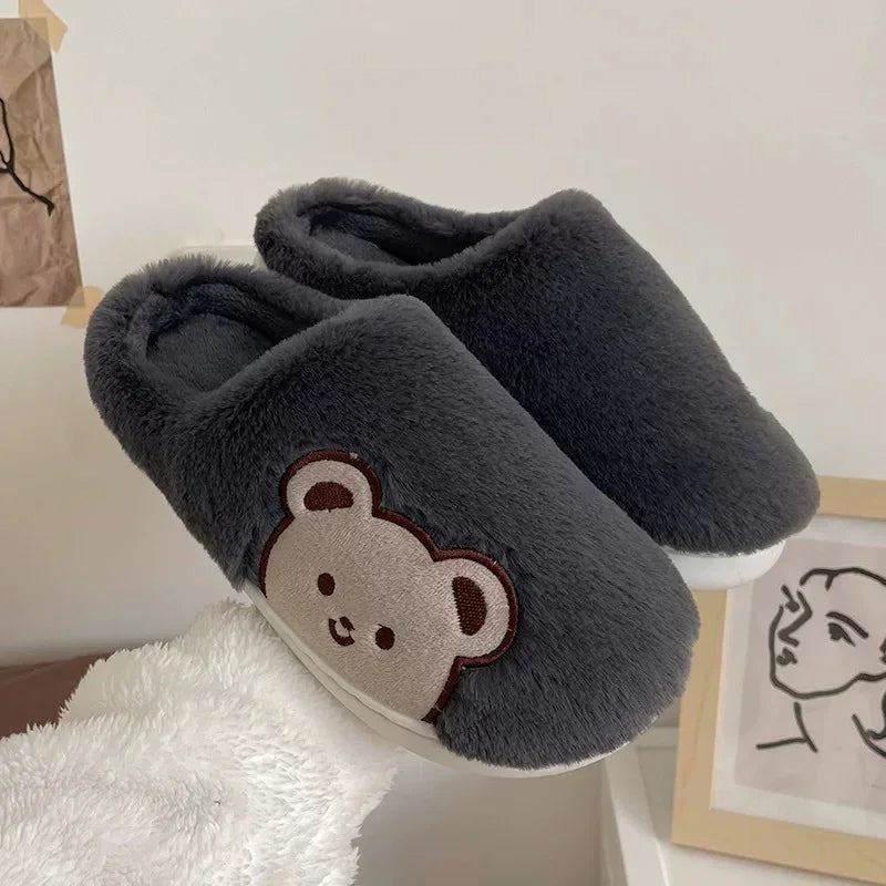 Cozy dark gray plush slippers with cute teddy bear patch on side, perfect for indoor wear