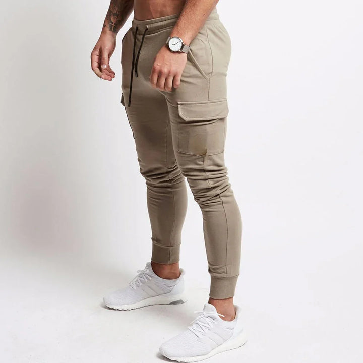 Man wearing slim fit beige cargo jogger pants with cuffs and white sneakers