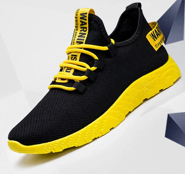 Black and yellow athletic sneaker with yellow sole and "WARNING" text on tongue and heel tab