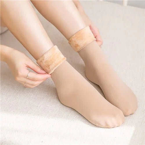 Person wearing beige fleece-lined ankle socks on a light-colored surface