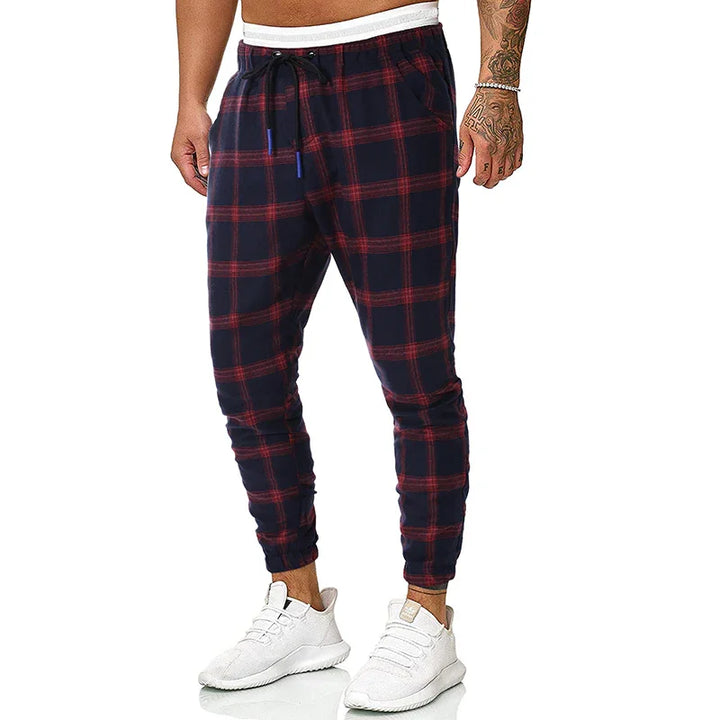 Men's navy blue and red plaid jogger pants with white waistband and white sneakers
