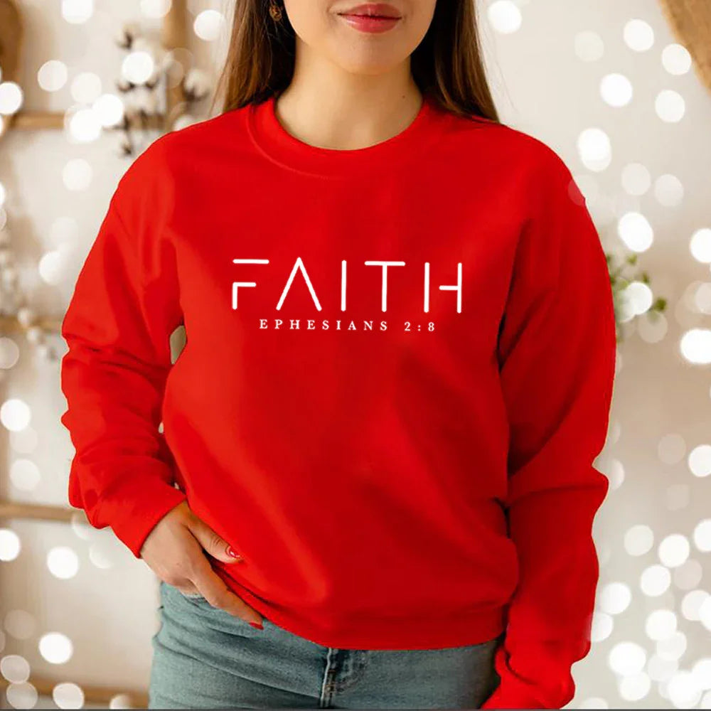 Woman wearing red sweatshirt with FAITH Ephesians 2:8 scripture text, casual denim jeans