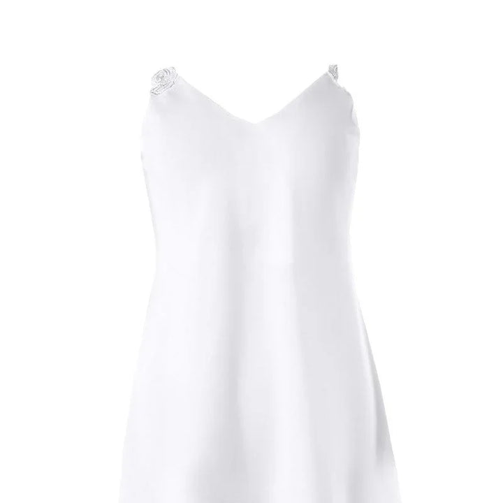 White satin slip dress with V-neck and delicate rosette straps on a white background