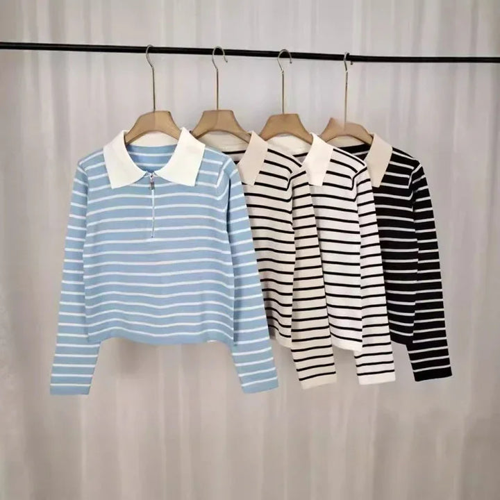 Striped long-sleeve polo shirts in blue, beige, white, and black hanging on wooden hangers