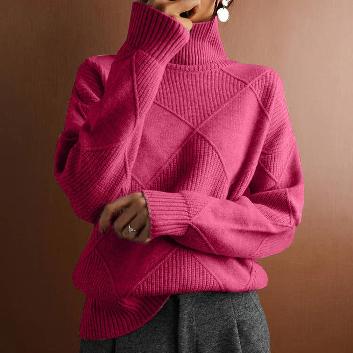 Woman wearing a pink cable knit turtleneck sweater with textured geometric patterns