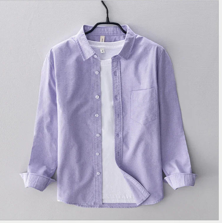 Light purple button-up shirt with front pocket layered over white t-shirt on black hanger