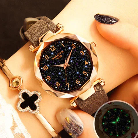 Women's wristwatch with starry black dial, rose gold case, and soft brown strap on wrist