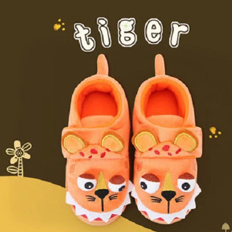 Orange tiger-themed baby slippers with cartoon faces and ears on dark background