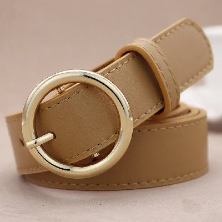 Tan leather belt with round gold buckle, elegant fashion accessory close-up