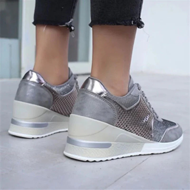 silver metallic wedge sneakers with mesh and suede details worn with black frayed hem jeans on concrete floor