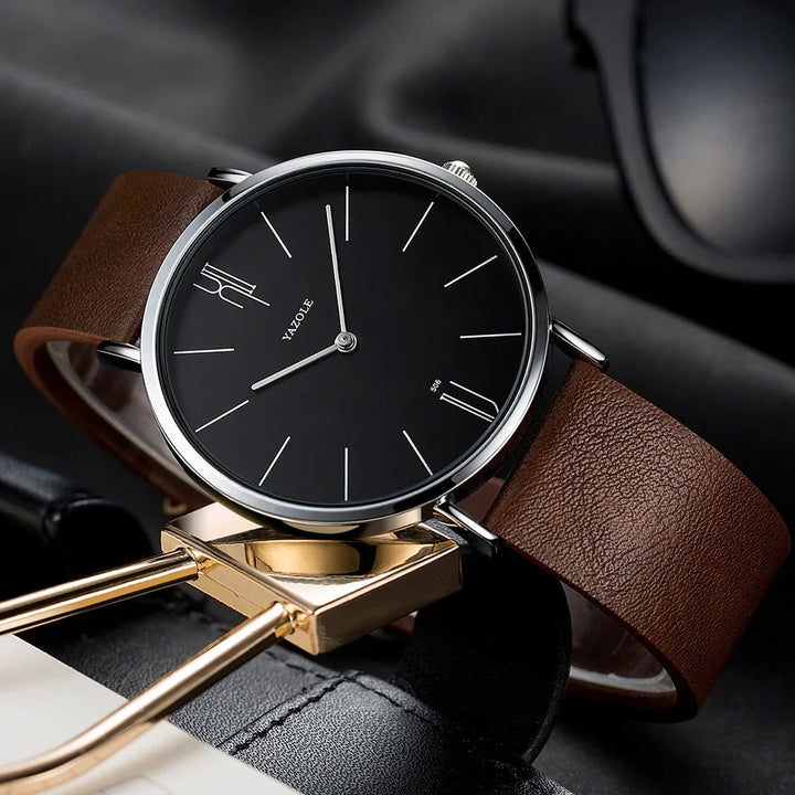 Yazole wristwatch with black minimalist dial and brown leather strap on a gold accessory