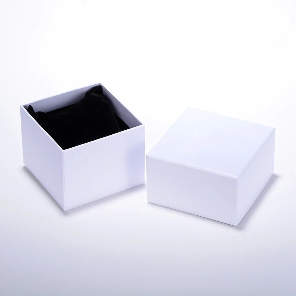 Open white jewelry box with black velvet cushion inside on white background
