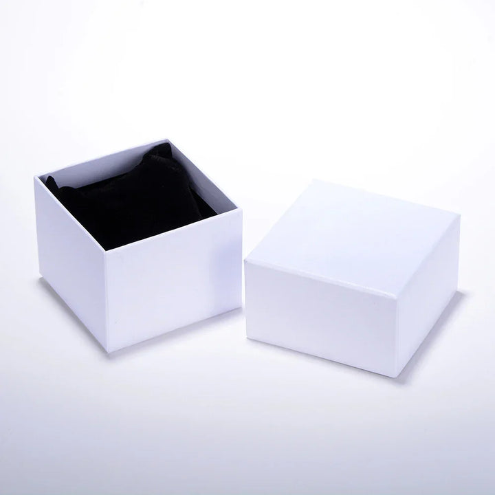 Open white jewelry box with black velvet cushion inside on white background