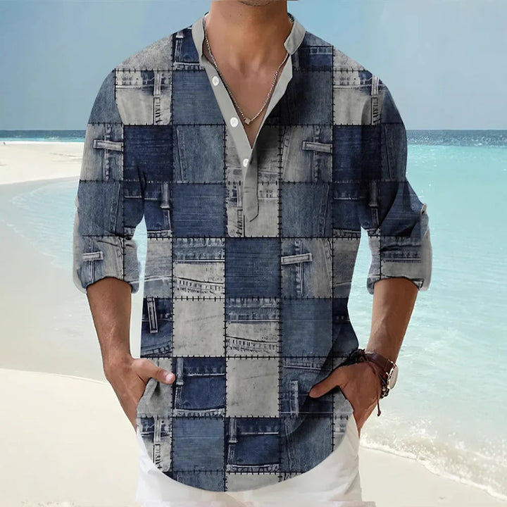 Man wearing patchwork denim print long sleeve shirt with rolled sleeves on beach background