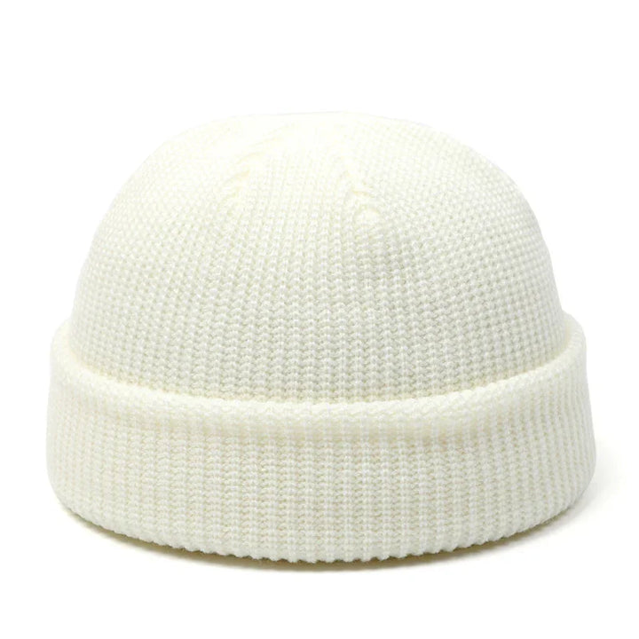 White knitted beanie hat with folded cuff, winter accessory on white background
