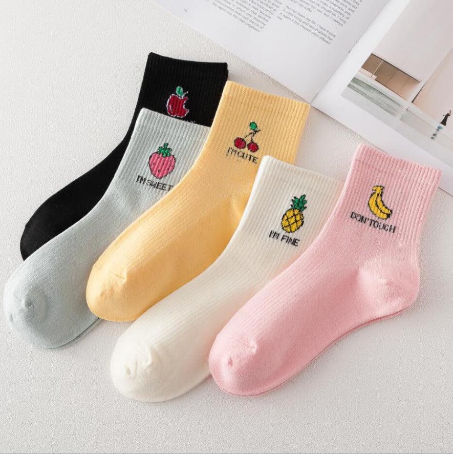 Set of five colorful cotton socks with fruit embroidery and text sayings, including apple, peach, cherry, pineapple, and banana designs