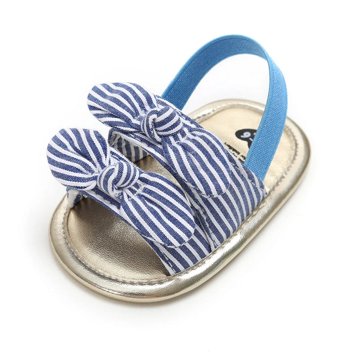 Baby sandal with blue and white striped fabric bows and blue elastic back strap on metallic sole
