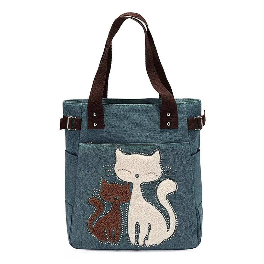 Blue tote bag with two embroidered cats and brown fabric handles