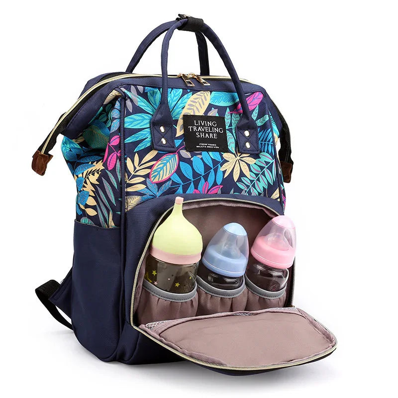 Colorful floral diaper backpack with separate front compartment holding three baby bottles