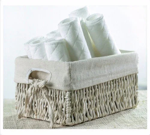 woven storage basket with white rolled towels on neutral surface