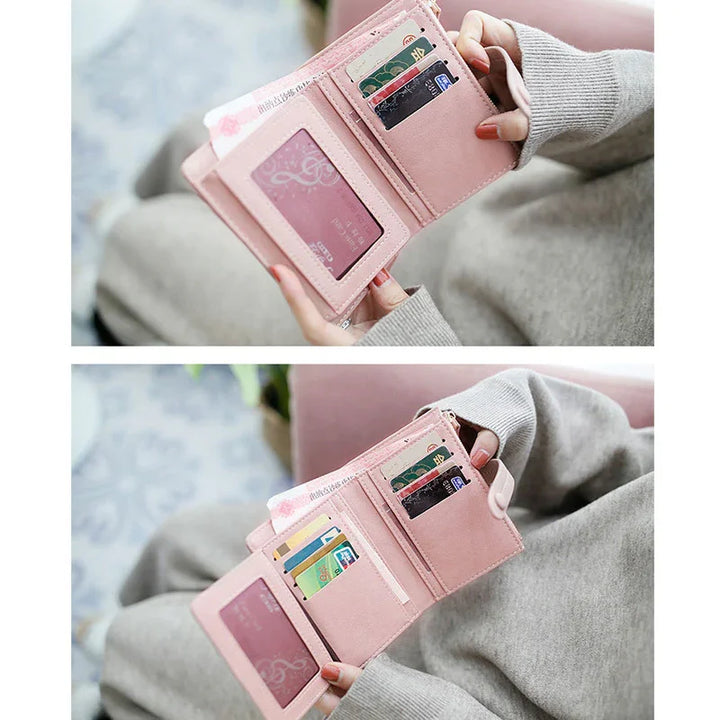 Person holding open pink leather wallet showing multiple card slots and cash compartments