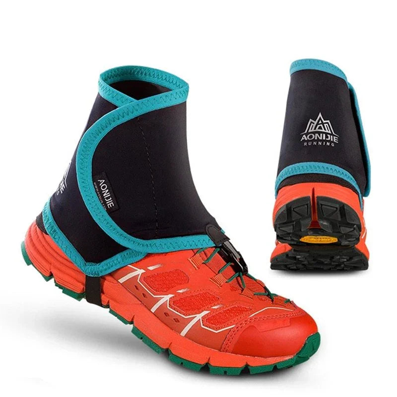 AONIJIE black and turquoise running gaiters paired with orange and green trail running shoes with rugged soles