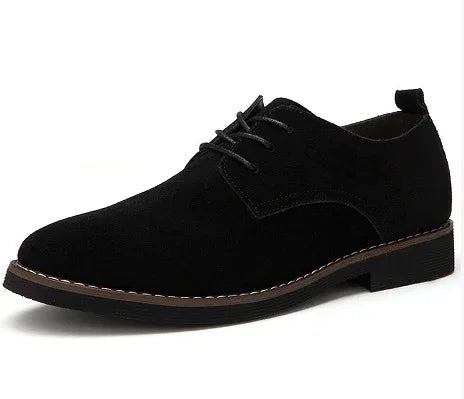 Black suede men's dress shoe with lace-up design and stitched sole on white background
