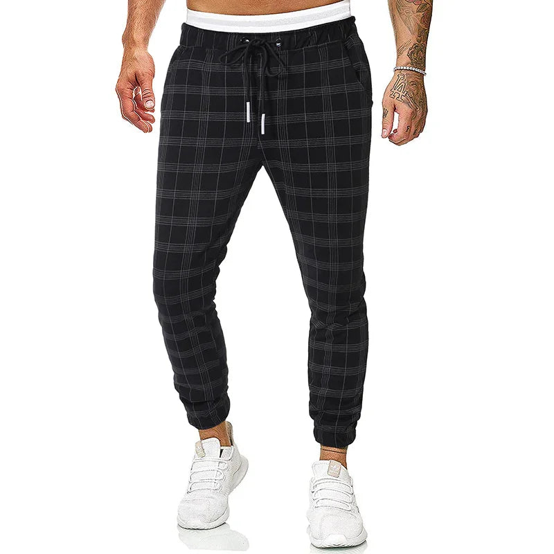 Men's black plaid jogger pants with white drawstring waistband and white sneakers