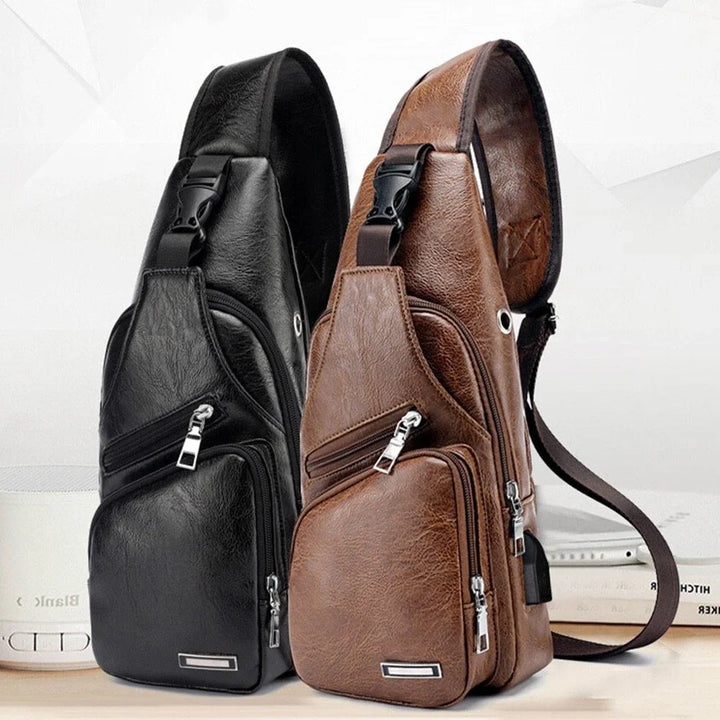 Black and brown leather sling bags with multiple zippered pockets and adjustable straps on white surface