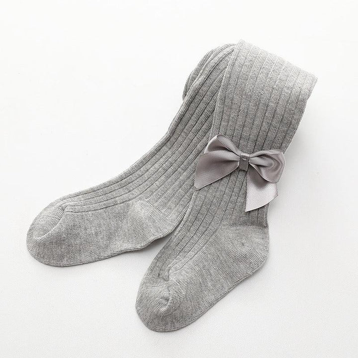 Pair of grey ribbed knit socks with decorative grey satin bow on white background