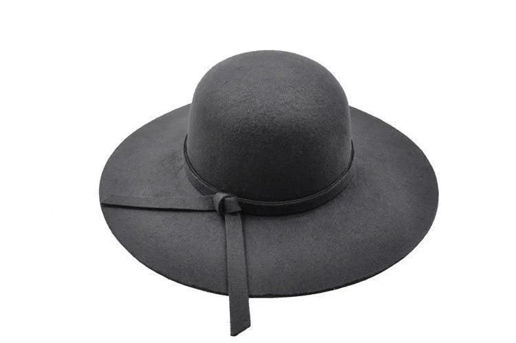 Black wide-brim felt hat with a tied ribbon band on a white background