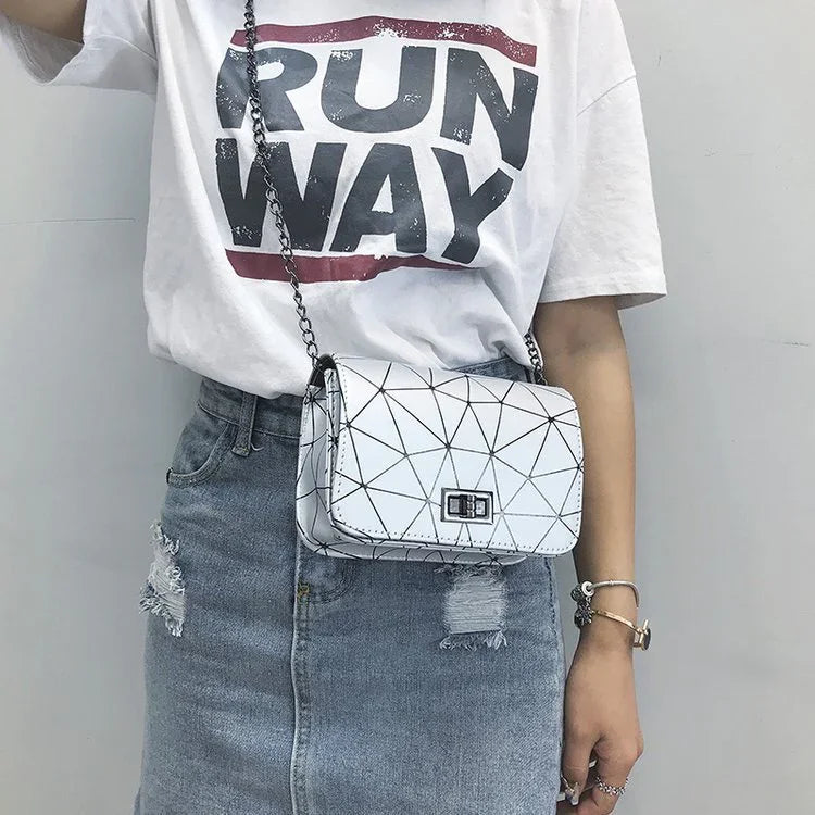 Woman wearing white graphic RUN WAY t-shirt, denim distressed skirt, and geometric crossbody bag with chain strap