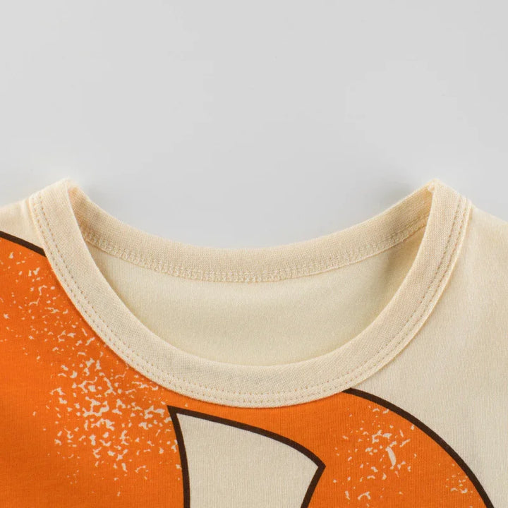 Close-up of beige crew neck T-shirt with faded orange graphic print detail