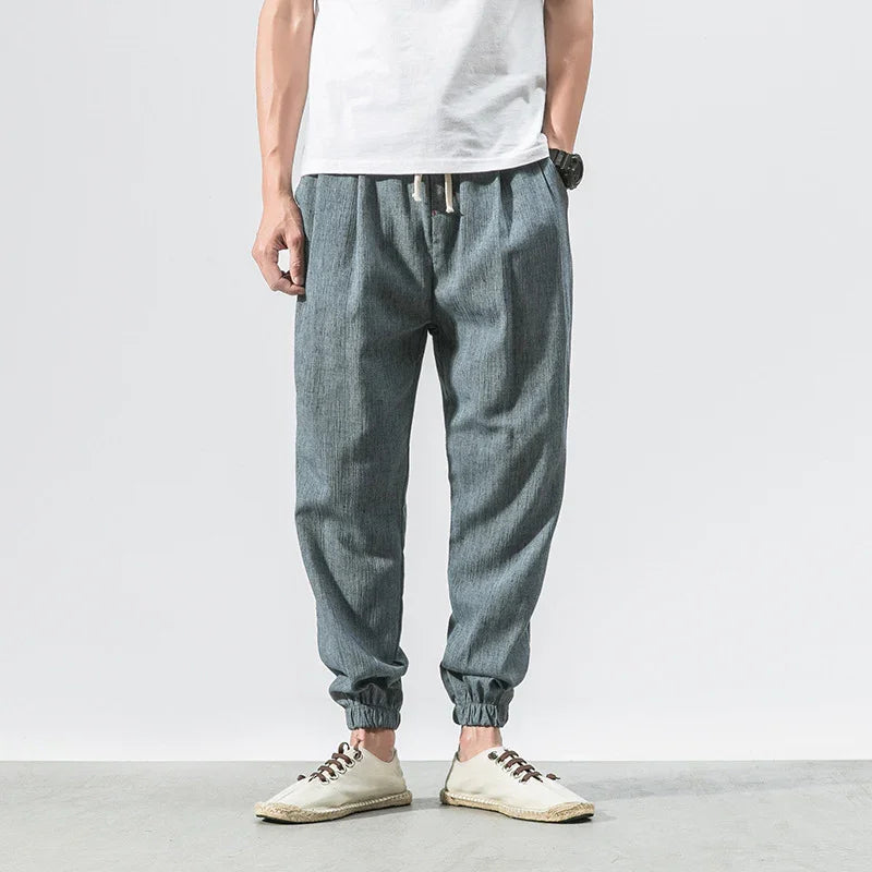man wearing gray jogger pants with elastic cuffs and beige casual shoes