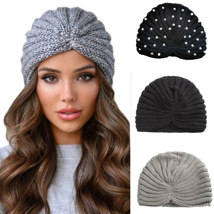 Woman wearing gray knitted turban headband with three additional black and gray knit turbans displayed