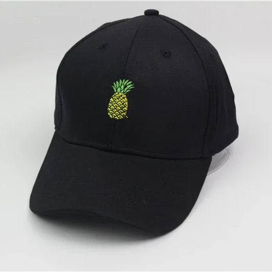 Black baseball cap with small embroidered yellow and green pineapple design on front
