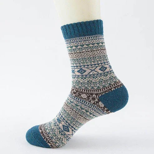 Blue and beige patterned wool sock with geometric design on white mannequin foot