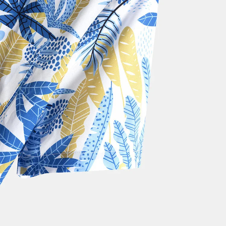 Close-up of fabric with blue and yellow tropical leaf print on white background